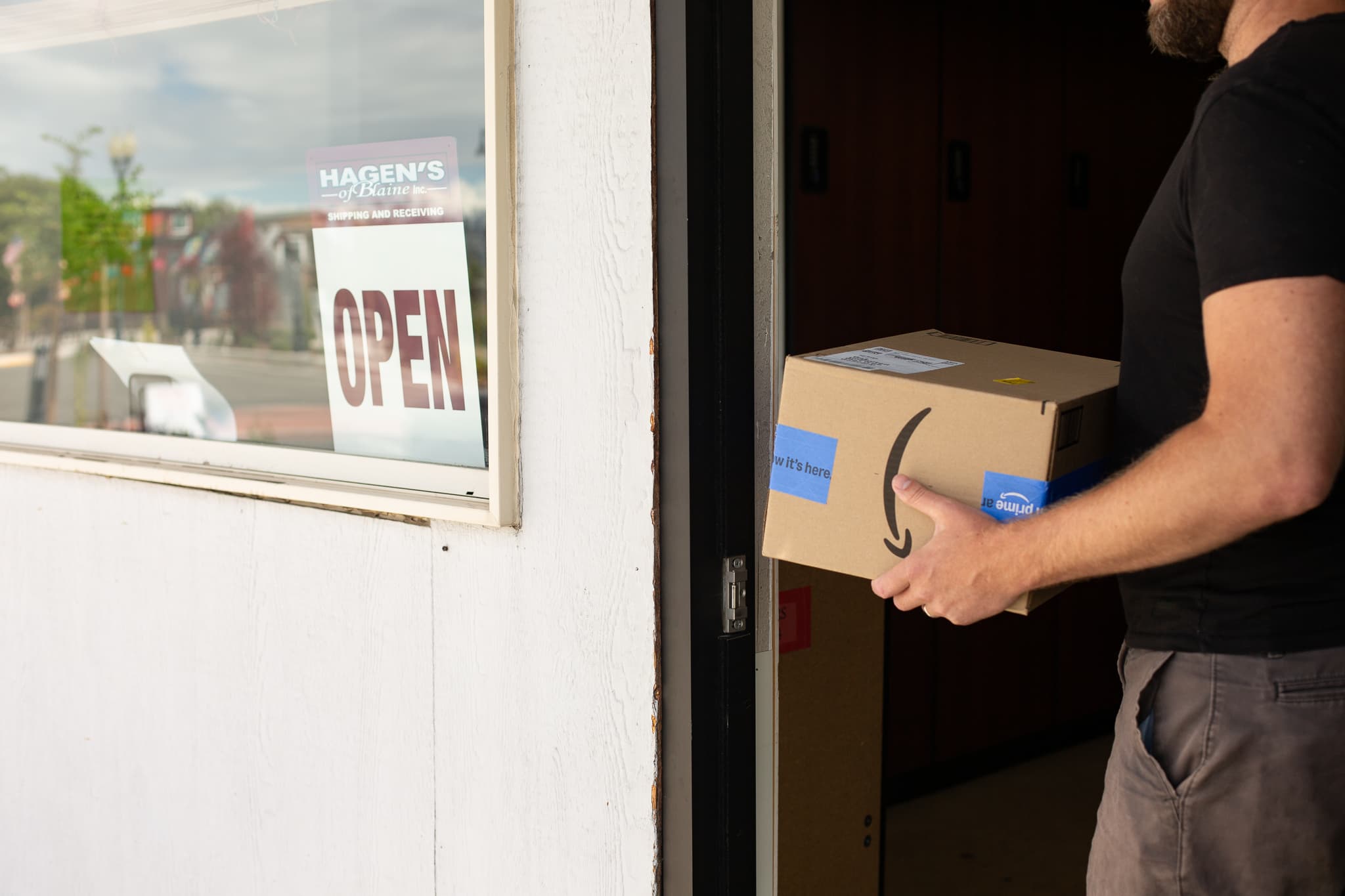 a man with a package in the door of hagens of blaine